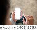 Close up of a person tapping white screen smartphone display, illustrating mobile app interaction. 140842569