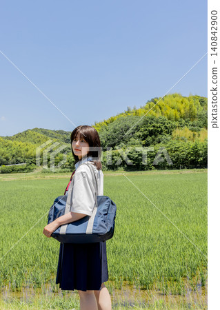 一張高中女生的肖像照，背景是藍天和稻田。 140842900