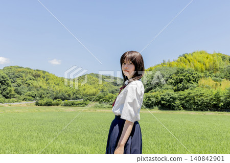 一張高中女生站在藍天和鄉村風景前的肖像照。 一張高中女生站在藍天和鄉村風景前的肖像照。 140842901