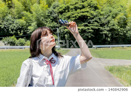 A high school girl taking a photo with an instant camera. A high school girl taking a photo with an instant camera. 140842906