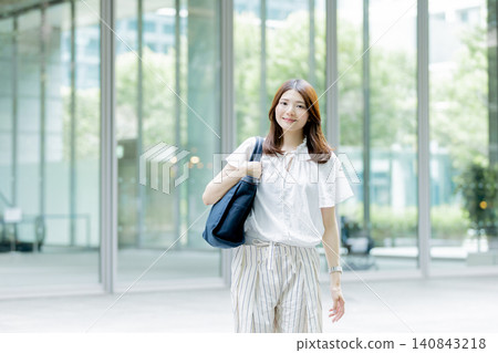 Japanese woman walking in front of an office building Japanese woman walking in front of an office building 140843218