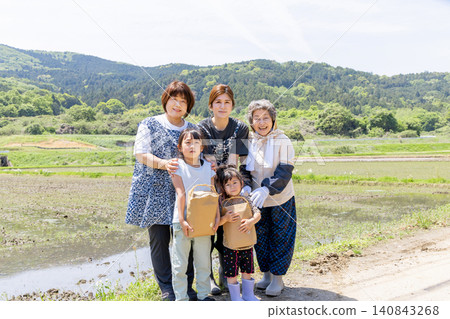 在鄉村的稻田裡,三代日本婦女和她們的孩子手捧收穫的農產品,臉上洋溢著笑容。 在鄉村的稻田裡,三代日本婦女和她們的孩子手捧收穫的農產品,臉上洋溢著笑容。 140843268