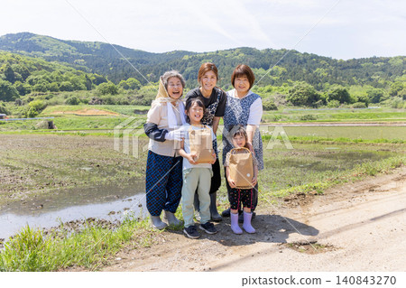 在鄉村的稻田裡,三代日本婦女和她們的孩子手捧收穫的農產品,臉上洋溢著笑容。 在鄉村的稻田裡,三代日本婦女和她們的孩子手捧收穫的農產品,臉上洋溢著笑容。 140843270