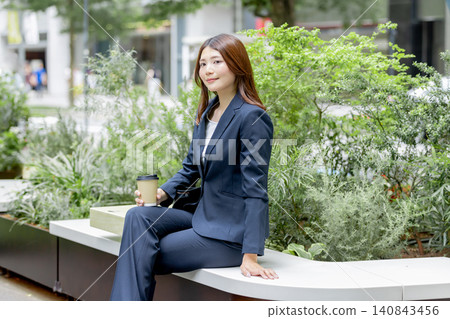 一位女商人正在城市綠地享受咖啡休息時間。 140843456