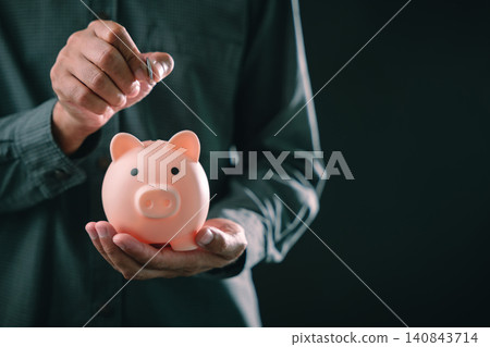 Personal savings financial planning concept with man holding pink piggy bank for retirement investment and wealth growth, putting silver coin inside for future security Personal savings financial planning concept with man holding pink piggy bank for retirement investment and wealth growth, putting silver coin inside for future security 140843714