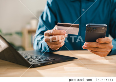 Secure online payment transaction, credit card, digital banking verification, process shows person using mobile phone and laptop at wooden desk for safe commerce and finance management Secure online payment transaction, credit card, digital banking verification, process shows person using mobile phone and laptop at wooden desk for safe commerce and finance management 140843754