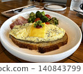Open-faced scrambled egg and cheese toast served with roasted broccoli and ham 140843799
