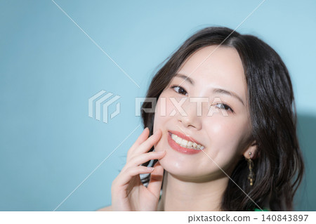 背景是藍綠色的，女子穿著色彩鮮豔、充滿活力的服裝，營造出美麗健康的可愛形象。 140843897