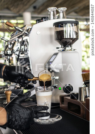 Barista at premium coffee shop preparing a Latte with professional equipment Barista at premium coffee shop preparing a Latte with professional equipment 140844087