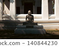Meditating Buddha Statue Before a Traditional Thai Temple in Ayutthaya 140844230