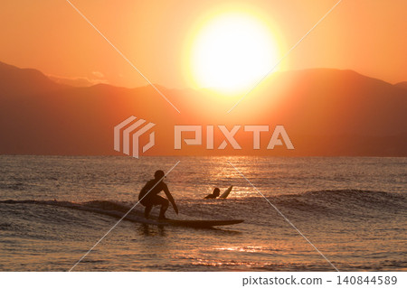 Shonan Kugenuma Beach: Sunset with a pollen halo and the silhouettes of surfers. Shonan Kugenuma Beach: Sunset with a pollen halo and the silhouettes of surfers. 140844589