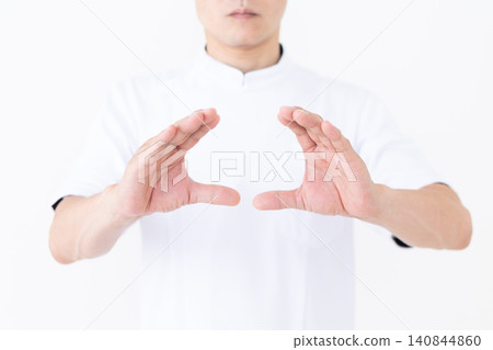 A middle-aged male acupuncturist/osteopath wearing a white coat. A middle-aged male acupuncturist/osteopath wearing a white coat. 140844860