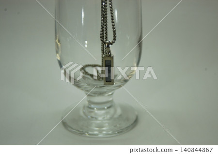 Glasses on the windowsill and a single pearl pendant 140844867