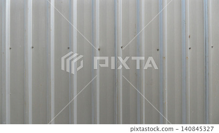 Full frame pattern showcasing a clean vertically corrugated metal wall sheet panel. The uniform metallic lines create a modern industrial grey background texture. 140845327