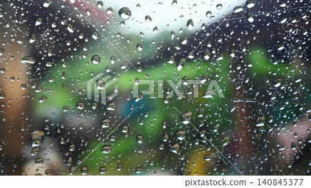 Raindrops on Glass Window with Blurred Green Nature Background Raindrops on Glass Window with Blurred Green Nature Background 140845377