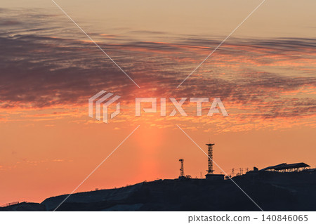 A dramatic sunrise scene where pillars of light, a mystery of nature, color the dawn sky. 140846065