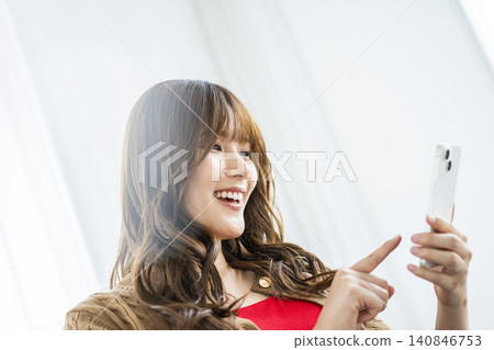 Young woman, smartphone, smiling, search, profile view Young woman, smartphone, smiling, search, profile view 140846753