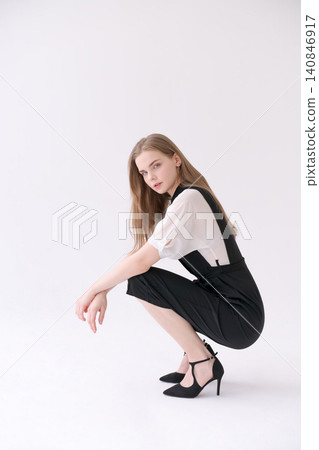 Young Woman in a Creative Crouching Pose in a Black Jumpsuit Lookbook 140846917