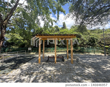Wooden shelter with bench offers shade in a lush green park setting 140846957