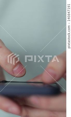 Vertical video Close up man using social media application on smartphone text messages receive news outdoor. Smartphone browsing internet, searching, reading news in social media. Vertical video Close up man using social media application on smartphone text messages receive news outdoor. Smartphone browsing internet, searching, reading news in social media. 140847191