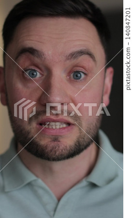 Vertical video Young man showing anger and emotion, expressing frustration and concern, raising his hands. Motions concept. Vertical video Young man showing anger and emotion, expressing frustration and concern, raising his hands. Motions concept. 140847201