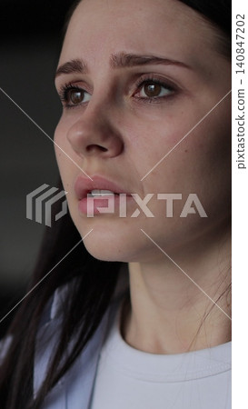 Vertical video Close up of young woman suffering from depression. Upset frustrated lonely lady thinking of grief troubled. Vertical video Close up of young woman suffering from depression. Upset frustrated lonely lady thinking of grief troubled. 140847202