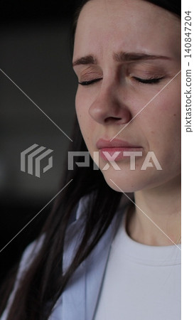 Vertical video Close up of young woman suffering from depression. Upset frustrated lonely lady thinking of grief troubled. Vertical video Close up of young woman suffering from depression. Upset frustrated lonely lady thinking of grief troubled. 140847204