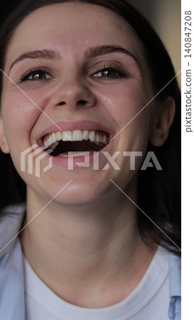 Vertical video Young woman demonstrates expresses a range of positive emotions, showcasing surprise and happiness, raising her hands. Vertical video Young woman demonstrates expresses a range of positive emotions, showcasing surprise and happiness, raising her hands. 140847208