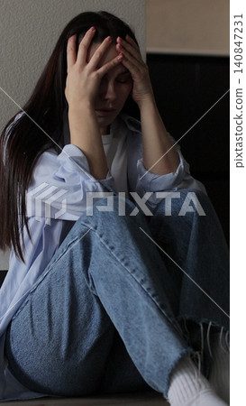 Vertical video Woman sitting on kitchen floor crying with head in hands. Family problems, stress. 140847231
