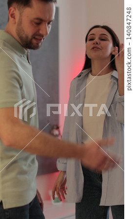 Vertical video A man and a woman are arguing in the living room, showing emotions and stress. Relationship crisis. Vertical video A man and a woman are arguing in the living room, showing emotions and stress. Relationship crisis. 140847248