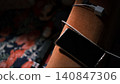 A mobile phone is lying next to the sofa with its charging cable. 140847306