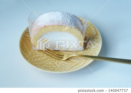 A blissful tea time, with a fluffy roll cake that looks beautiful on the plate. A blissful tea time, with a fluffy roll cake that looks beautiful on the plate. 140847737
