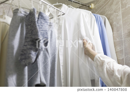 Checking the drying progress of clothes dried indoors. 140847808