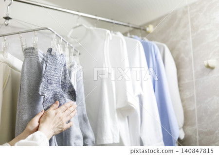 Checking the drying progress of clothes dried indoors. Checking the drying progress of clothes dried indoors. 140847815