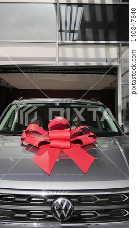 Vertical video Family buying a new car with red bow at a dealership, excited about their new purchase. New car riding out of modern auto salon. Concept of car shopping, buying. Vertical video Family buying a new car with red bow at a dealership, excited about their new purchase. New car riding out of modern auto salon. Concept of car shopping, buying. 140847840