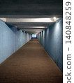 Long illuminated underground pedestrian tunnel with strong perspective leading toward daylight. Urban architecture creating minimalist geometric composition, symmetry, depth, and passage concept 140848259