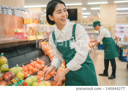 超市蔬果區一位面帶微笑的女員工。 超市蔬果區一位面帶微笑的女員工。 140848277