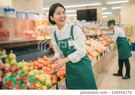 超市蔬果區，一名女店員大聲笑著。 140848278