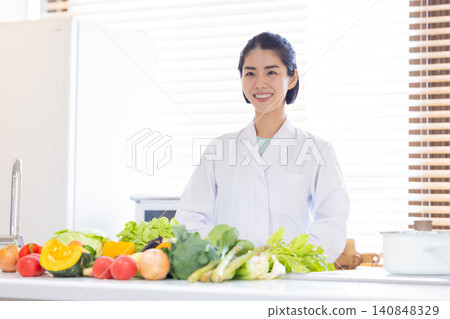 Registered Dietitian: A dietitian smiling in front of lots of vegetables. Registered Dietitian: A dietitian smiling in front of lots of vegetables. 140848329
