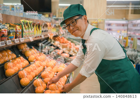 Smiling male clerk at the produce section of a supermarket Smiling male clerk at the produce section of a supermarket 140848613