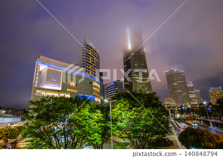 The urban landscape of Yokohama, Japan, shrouded in mist... Fresh greenery in front of Sakuragicho Station and low-hanging dark clouds... The top of Yokohama Landmark Tower... 140848794