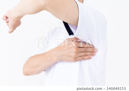 A middle-aged male acupuncturist/osteopath in a white coat presses on an acupressure point (serratus anterior muscle) under the armpit that is effective for stiff shoulders. A middle-aged male acupuncturist/osteopath in a white coat presses on an acupressure point (serratus anterior muscle) under the armpit that is effective for stiff shoulders. 140849153