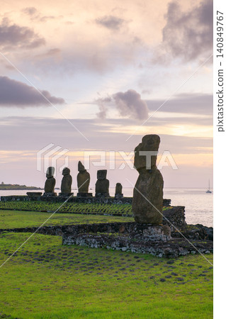 Peaceful sunset behind ancient moai statue on easter island chile Peaceful sunset behind ancient moai statue on easter island chile 140849767