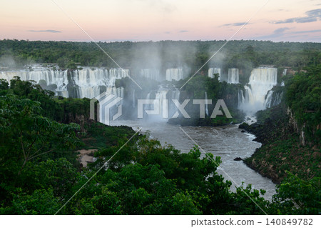 Serene iguazu falls waterfall flowing through lush green jungle with peaceful morning mist Serene iguazu falls waterfall flowing through lush green jungle with peaceful morning mist 140849782