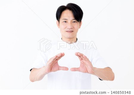 A middle-aged male acupuncturist/osteopath wearing a white coat. 140850348