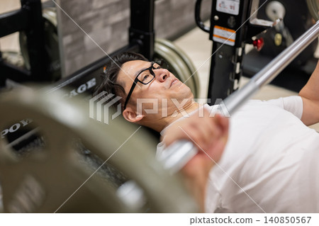 一名男子在健身房做臥推。 一名男子在健身房做臥推。 140850567