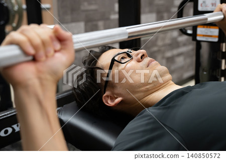 A man doing bench presses at the gym A man doing bench presses at the gym 140850572