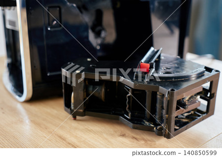 Removed coffee machine brewing unit on wooden countertop 140850599