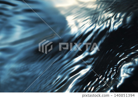 A shimmering, rippling water surface against a black background (background material/texture) 140851394