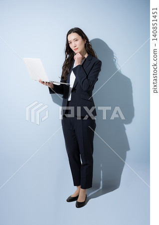 一張全身照,一位面帶微笑的日本女商人身穿西裝,在淺藍色背景下看著筆記型電腦,象徵數位轉型、人工智慧和業務改進。 一張全身照,一位面帶微笑的日本女商人身穿西裝,在淺藍色背景下看著筆記型電腦,象徵數位轉型、人工智慧和業務改進。 140851451